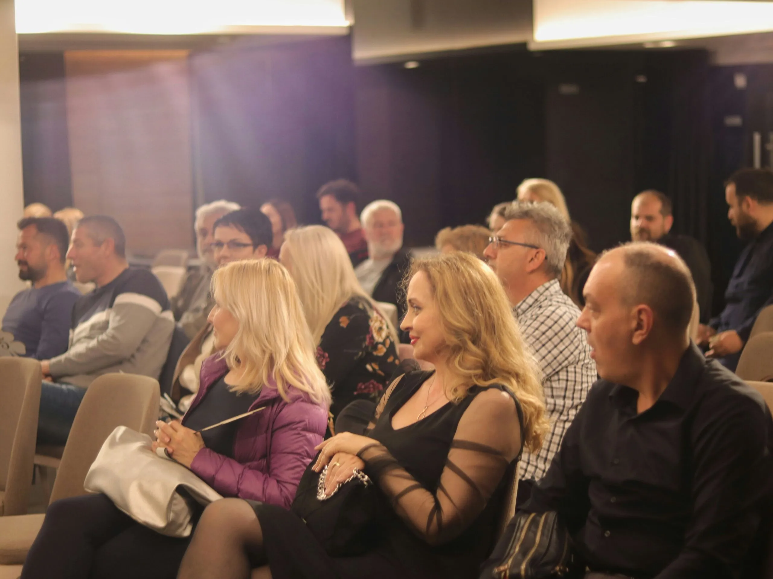 A corporate audience laughing during a show